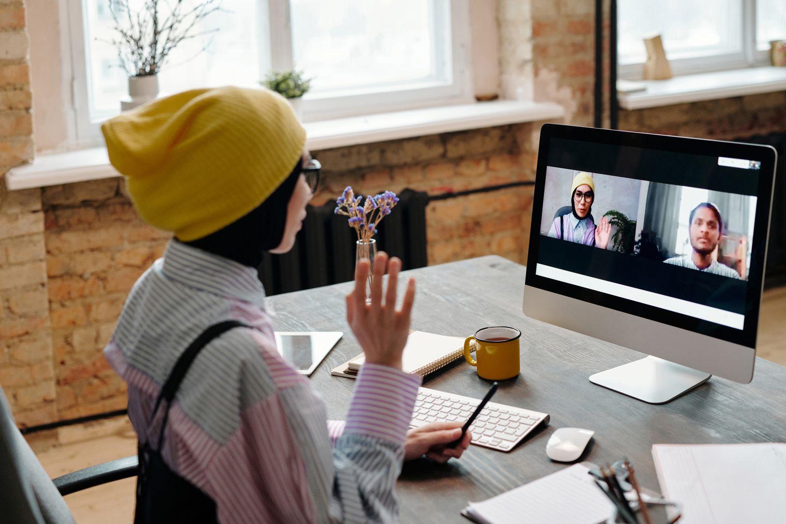 Une femme en visioconférence à son bureau depuis son domicile