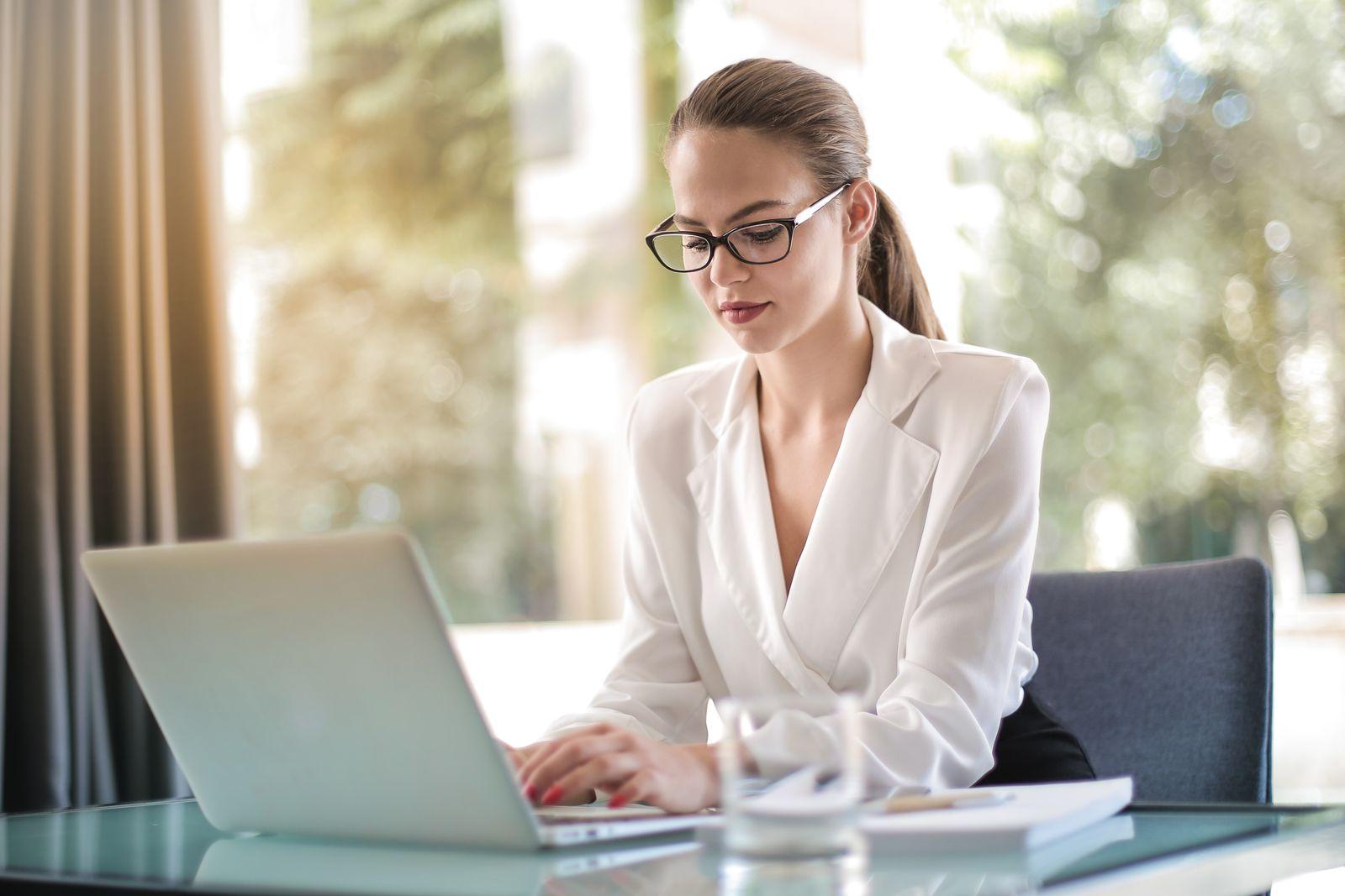 Femme professionnelle travaillant sur un ordinateur portable dans un bureau lumineux