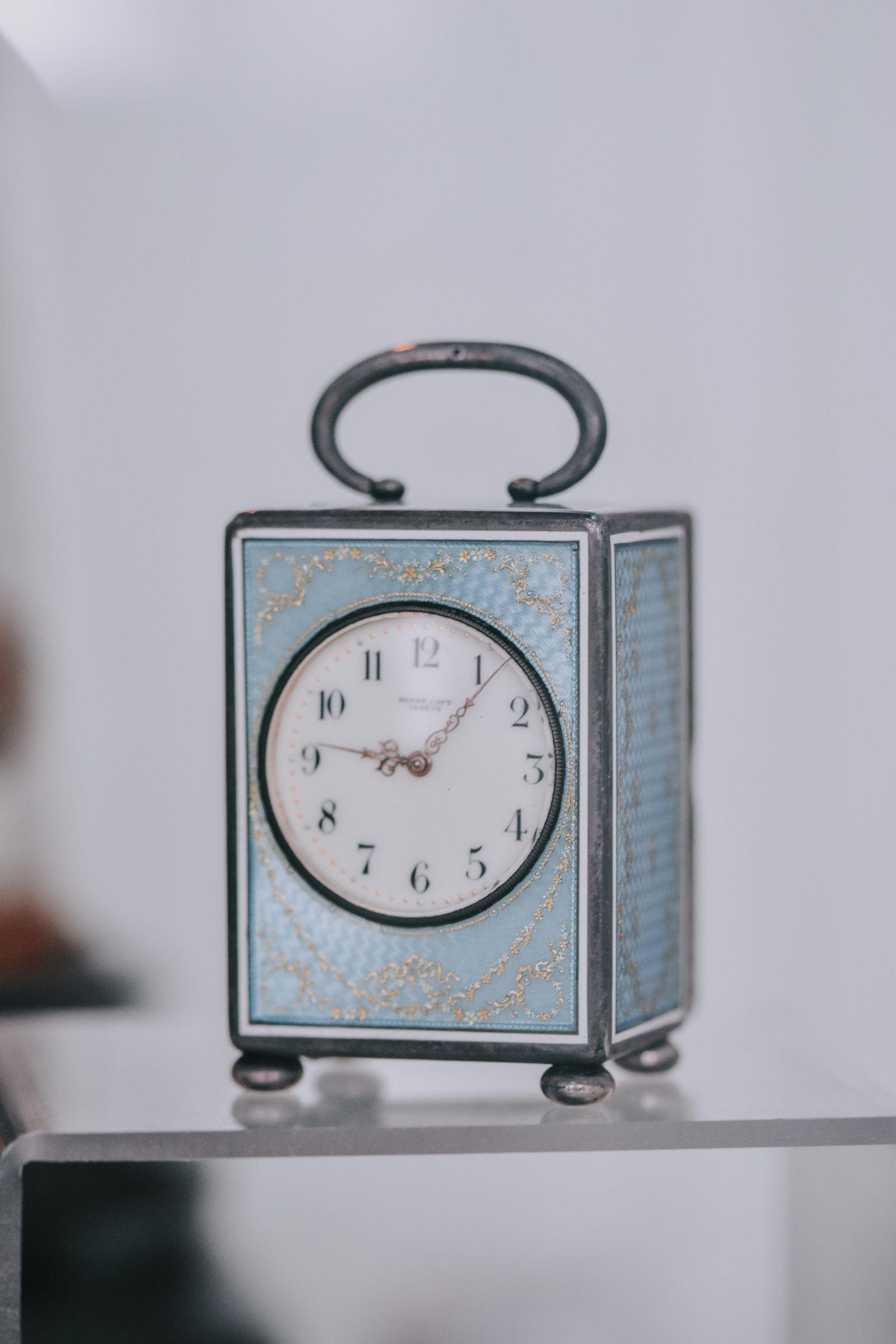 Petite horloge décorative posée sur une étagère, symbole du temps