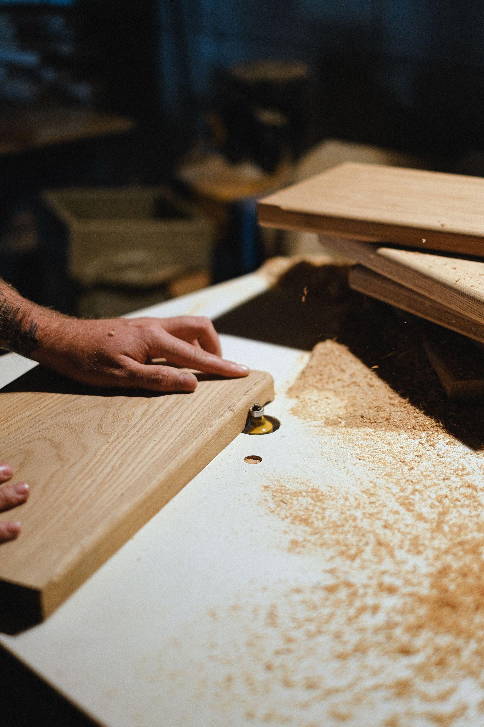 Artisan menuisier travaillant le bois sur un établi dans son atelier