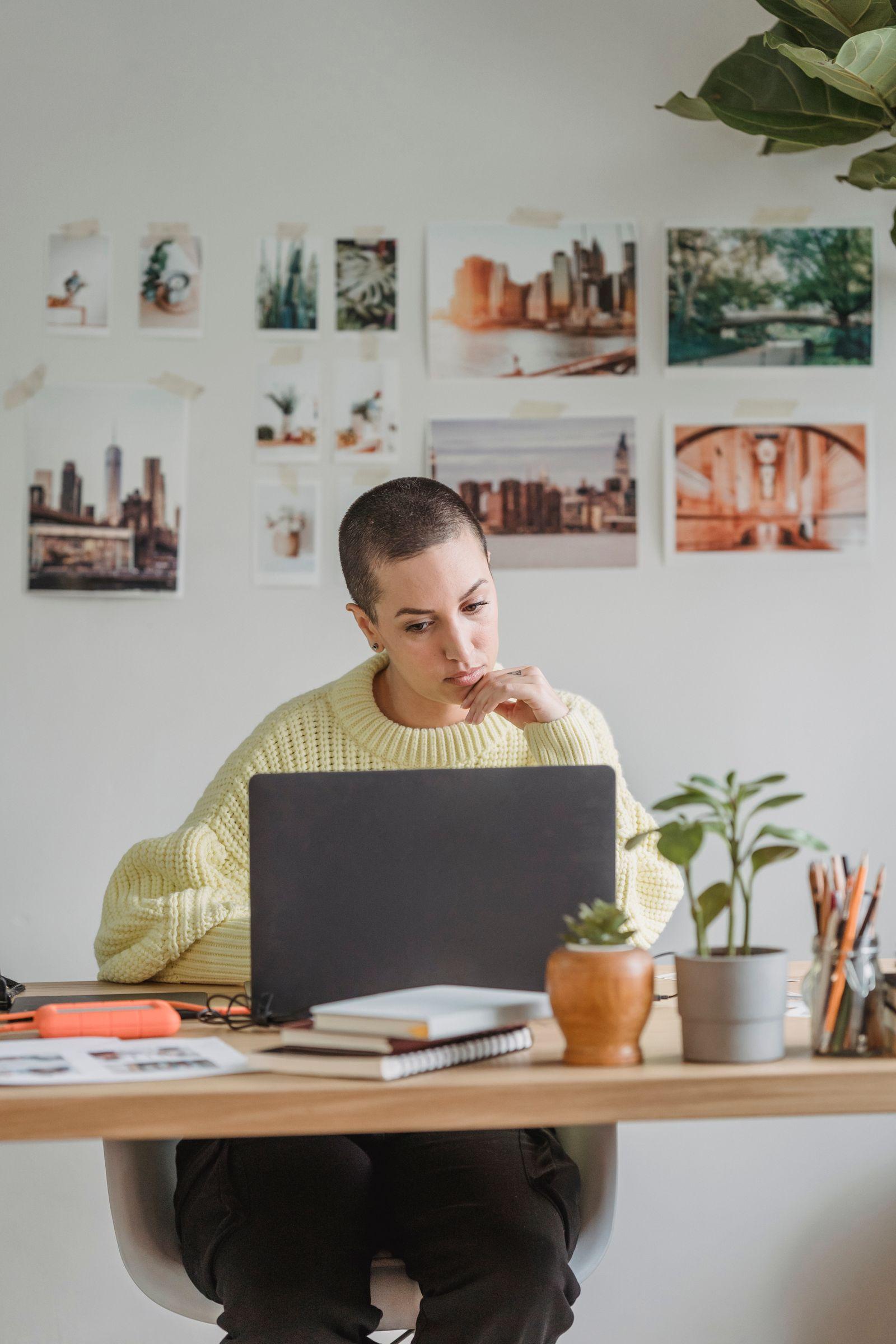 Femme pensive travaillant sur un ordinateur portable à son bureau