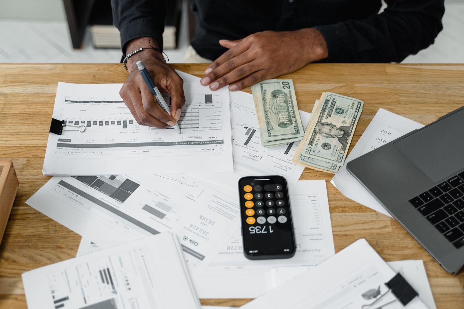 Espace de travail avec calculatrice, billets et ordinateur portable pour la gestion comptable