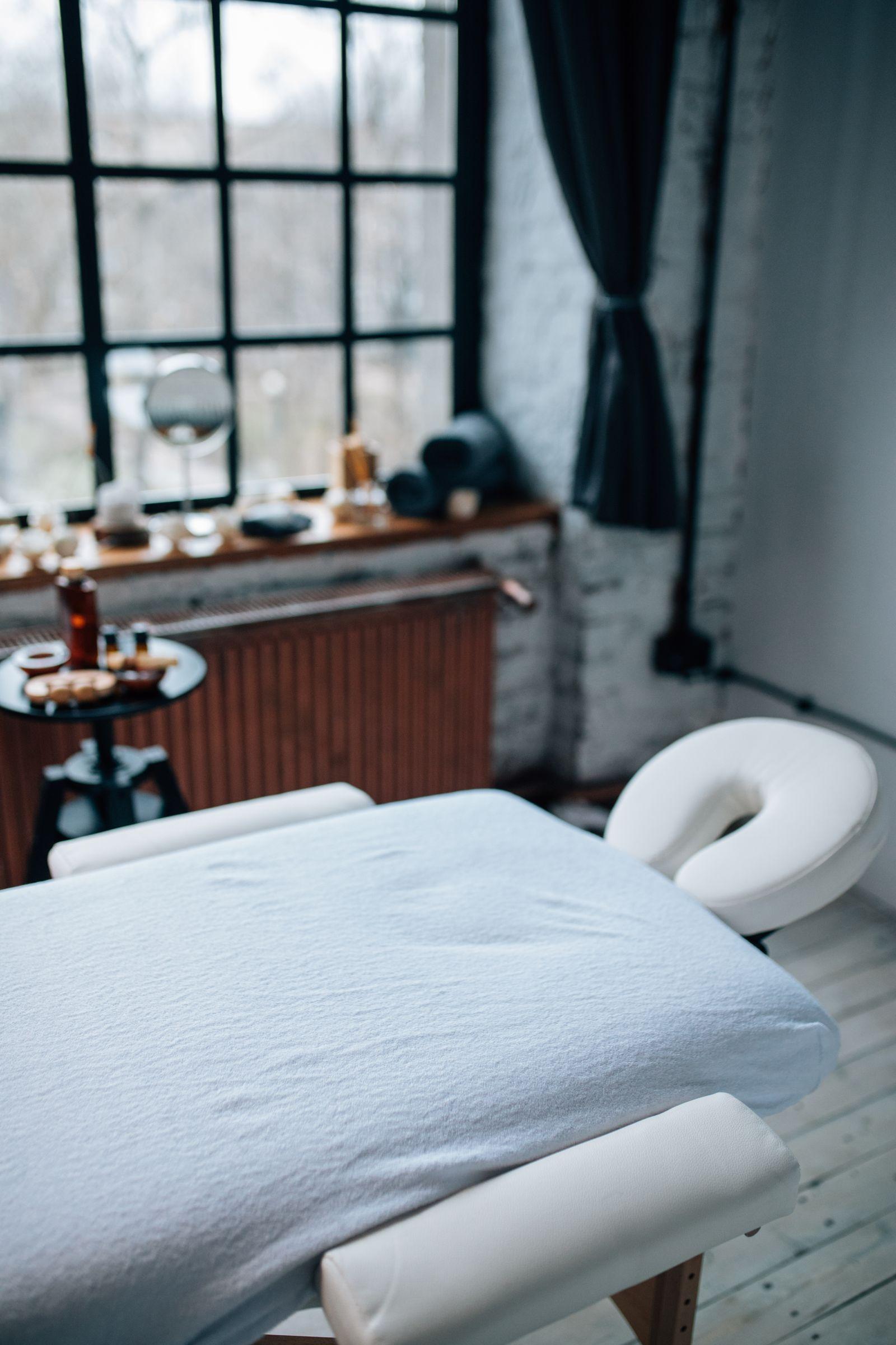 Table de massage préparée dans une salle de soin lumineuse et épurée