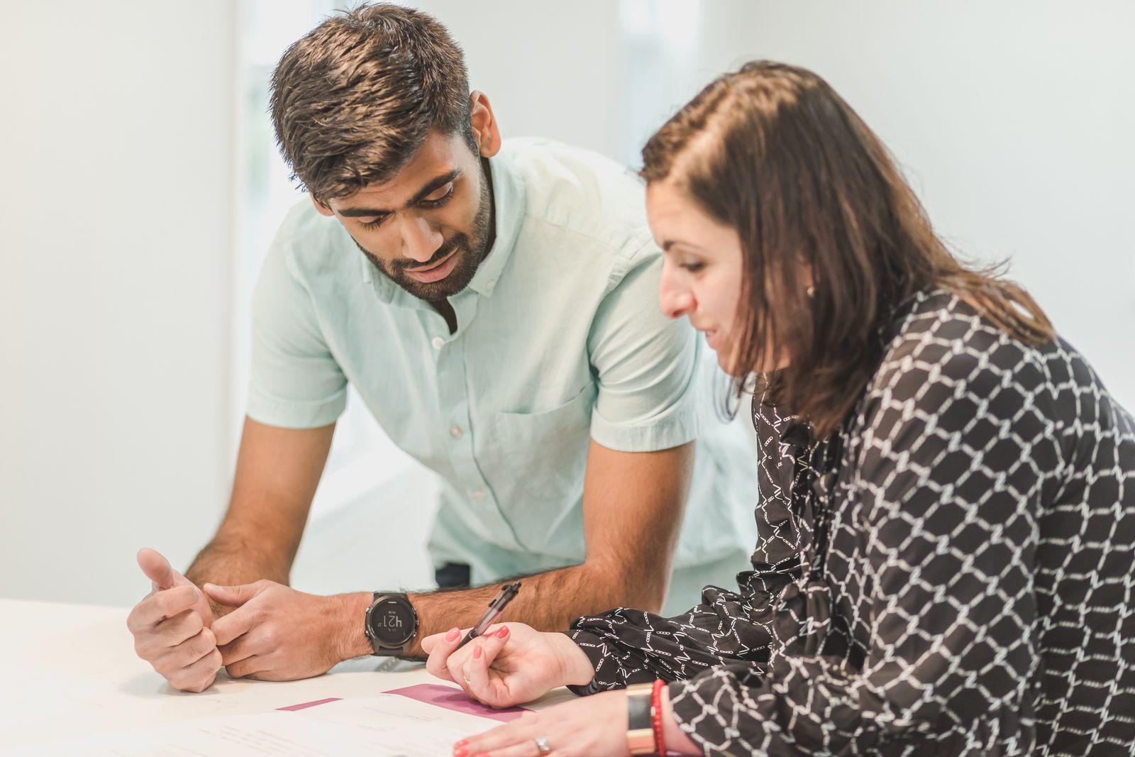 Un homme et une femme penchés ensemble sur un document de travail