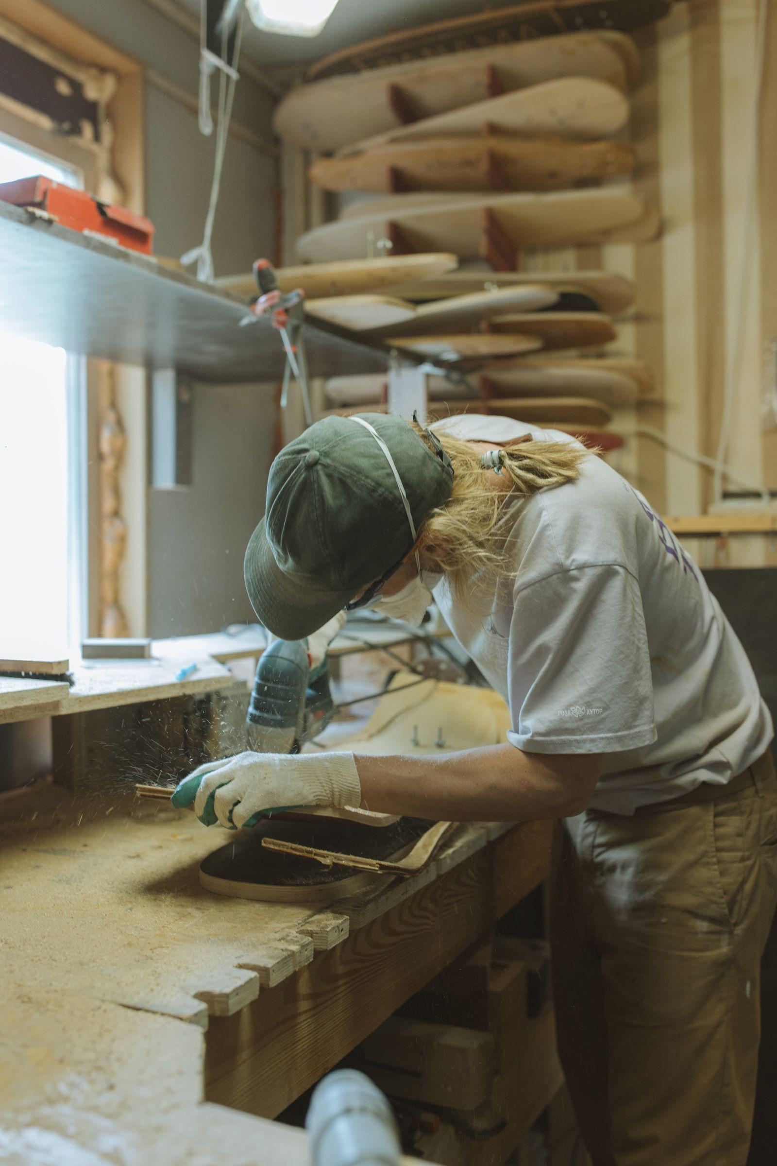 Artisan concentré travaillant sur une pièce dans son atelier, entouré d'outils
