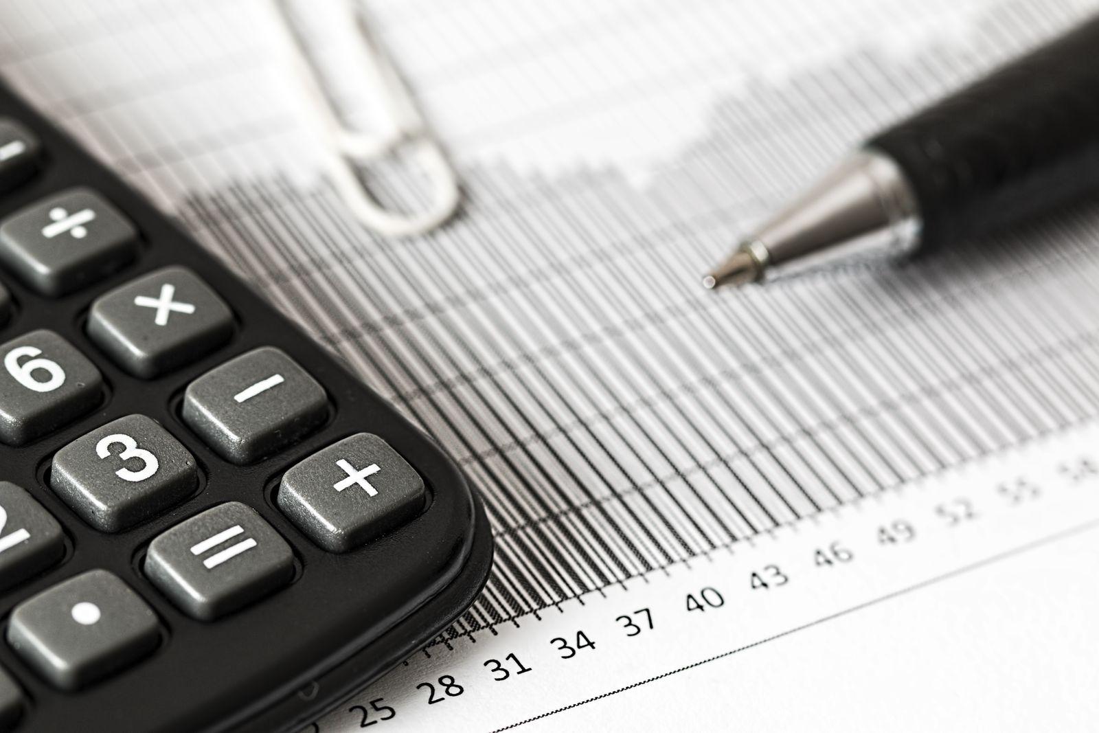 Calculatrice et stylo posés sur un graphique imprimé, gros plan